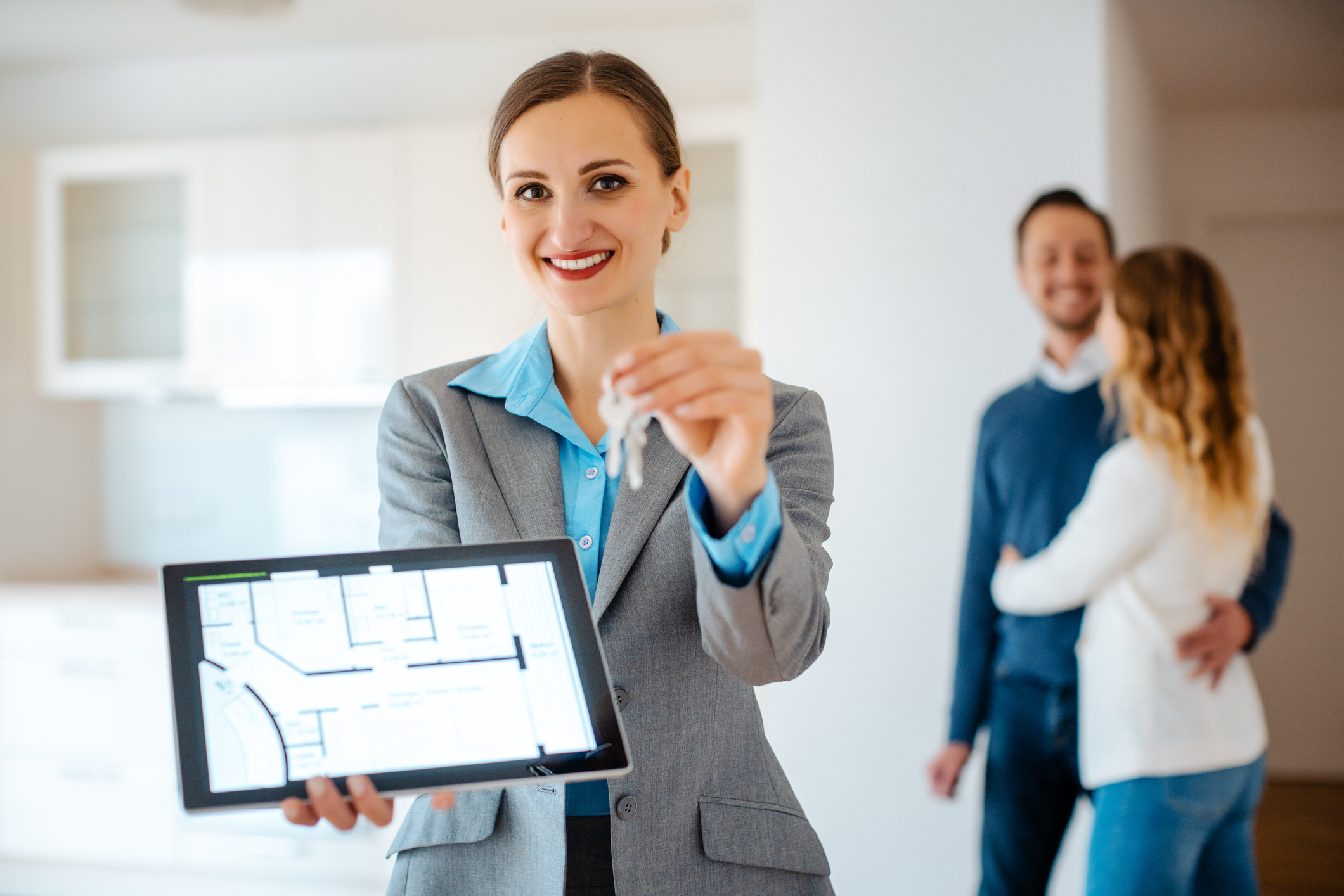 real estate agent with keys showing floorplan of rental apartment