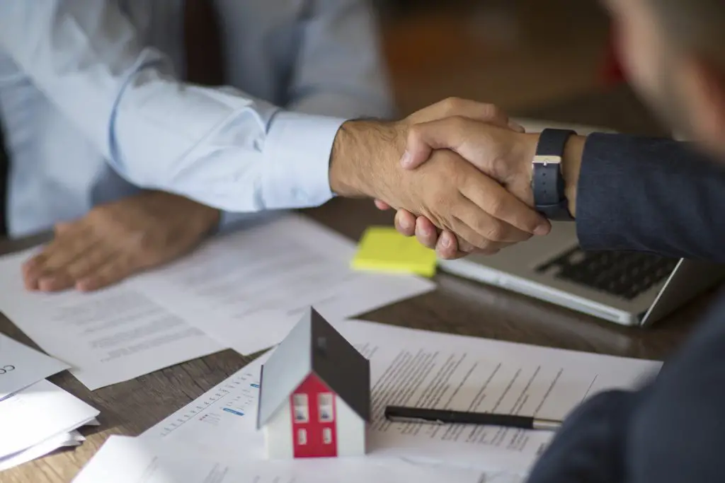 Estate agent shaking hands with his customer after contract signature